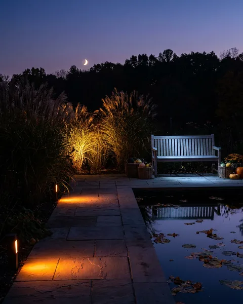 Twilight garden path lit beside a reflecting pool