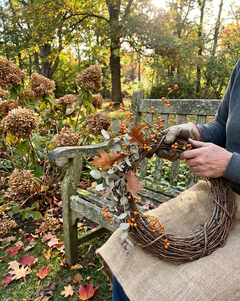 Making an autumn wreath beside a garden bench