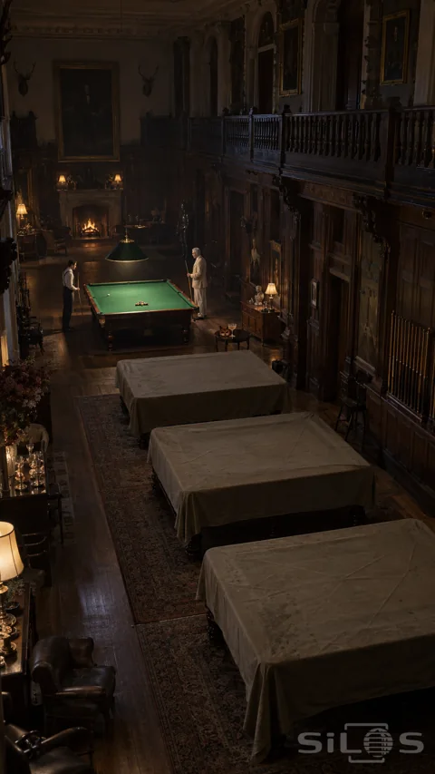 Two distant men at a green billiard table in a tall oak-panelled room; with three sheeted tables and an upper gallery.