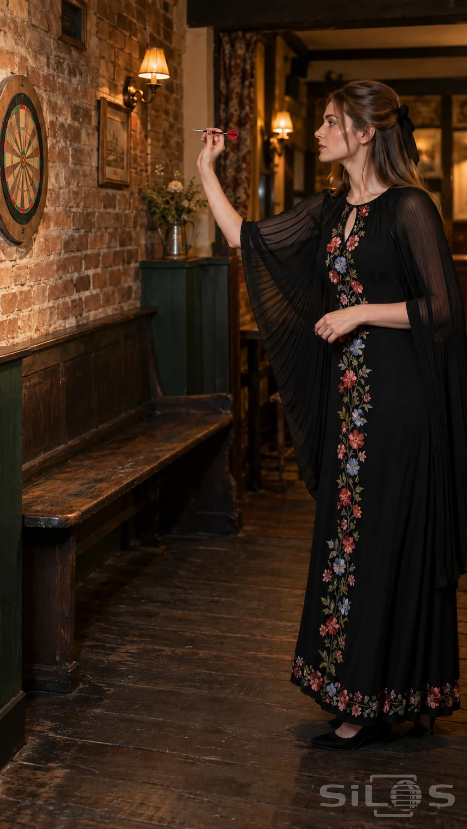 Adult woman in a floral cape dress holds a red dart near her shoulder beside a cork board in a warmly lit pub.