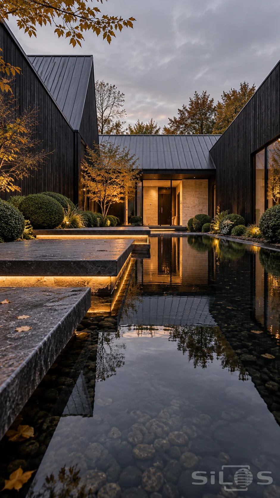 A dark timber courtyard surrounds a clear reflecting pool, glowing stone steps, rounded shrubs and a warm recessed entrance.
