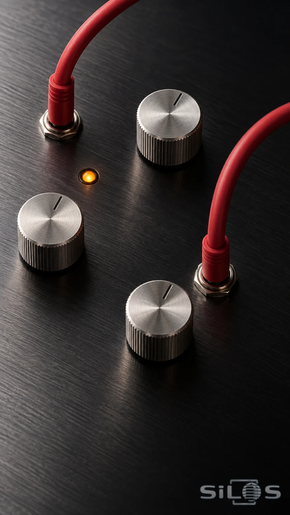 Two red patch cables connect beside three silver knobs and an amber light on a dark metal synthesizer panel.